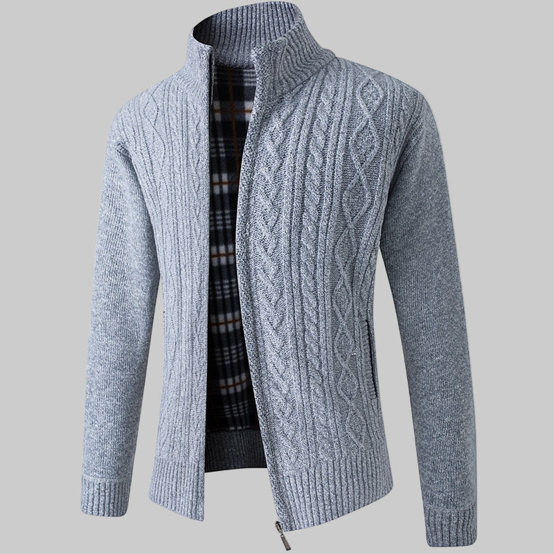 Gray cable knit sweater with a plaid shirt underneath on a white background