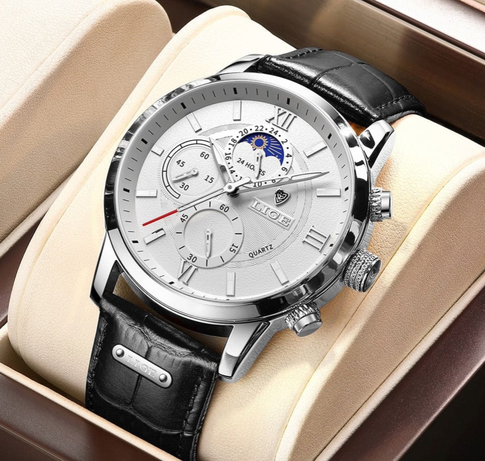 Luxury watch with black leather strap and silver case on beige cushion